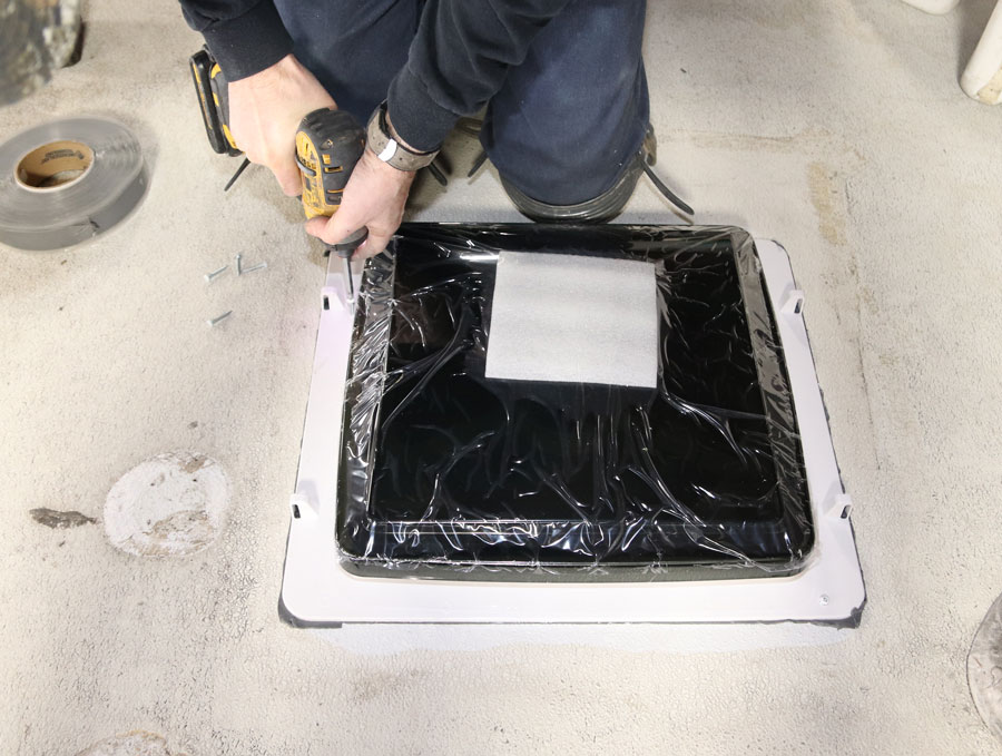 Slightly lift one side at a time and peel the paper or cover away from the tape. Screw down the four corners, then install the remaining screws