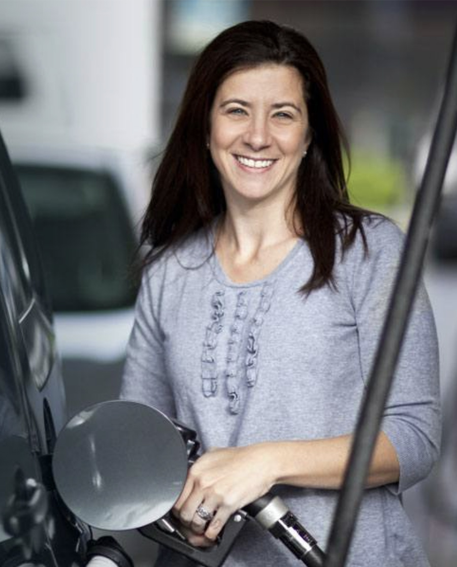 Smiling woman filling up gas using GasBuddy