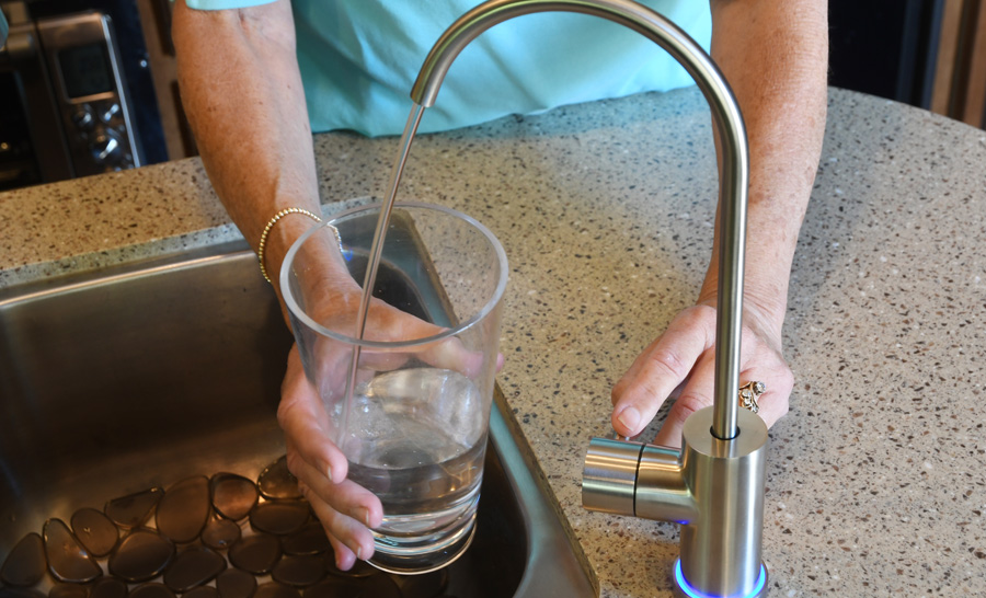 sink being used to fill a glass of water