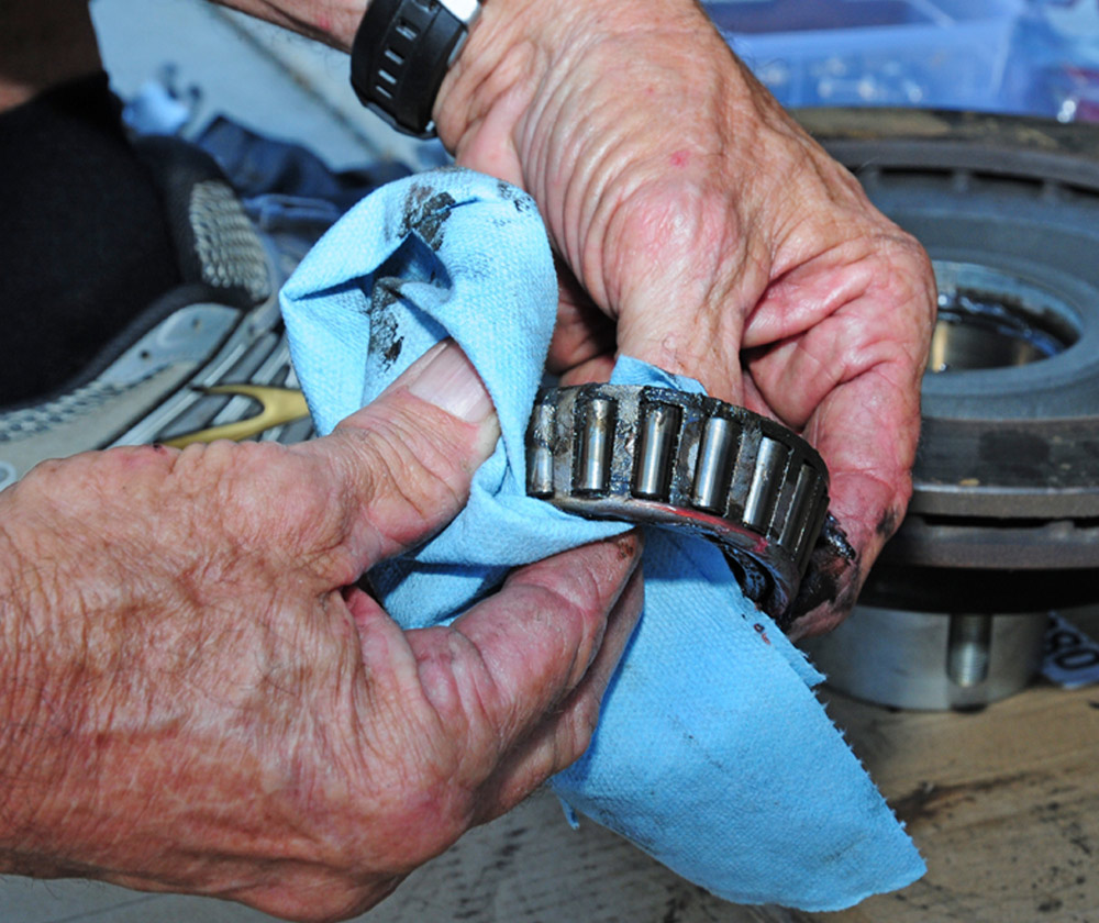 mechanic cleans old grease of inner bearing and inspects