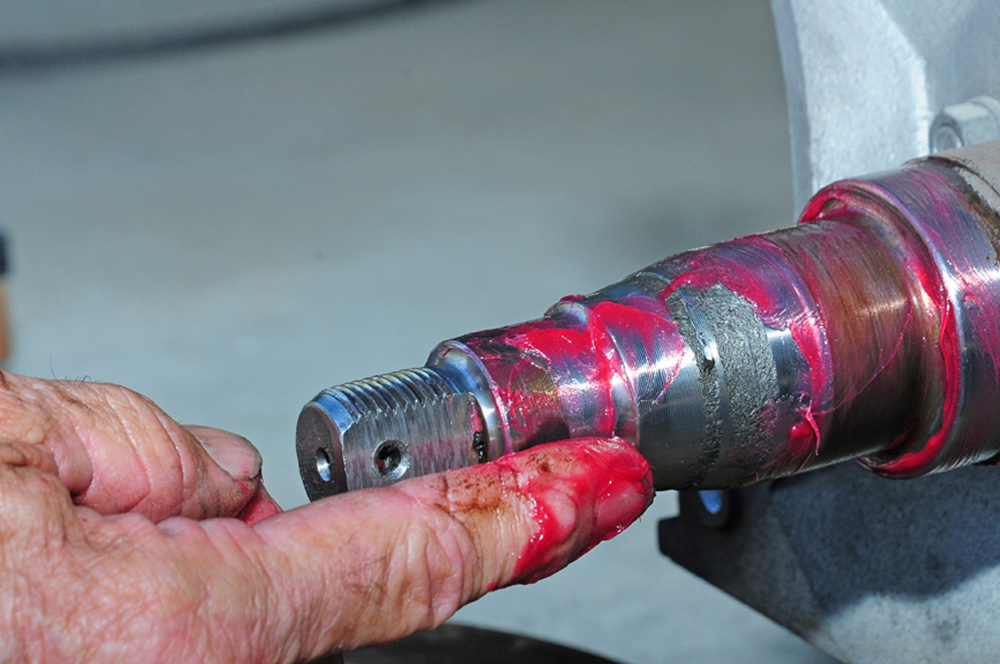 mechanic adds a thin layer of grease to axle spindle