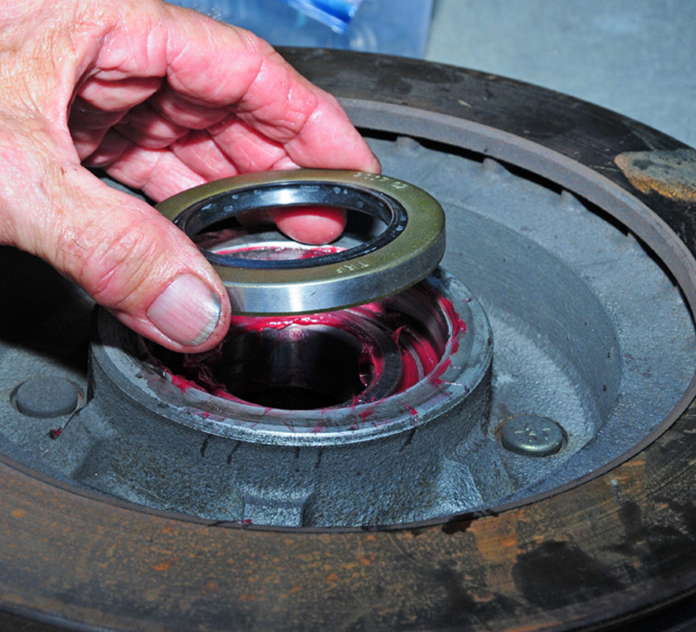 mechanic carefully installs the grease seal, level to rotor/drum