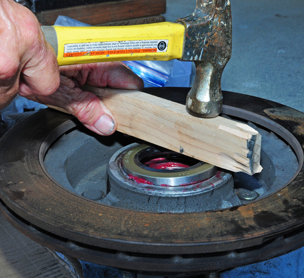 mechanic uses hammer and piece of wood in place of installation tool