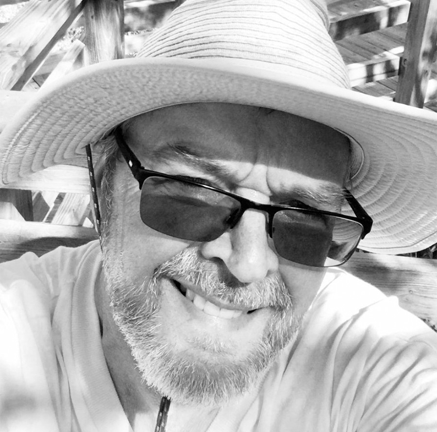 Jim Mac smiling with sunglasses on