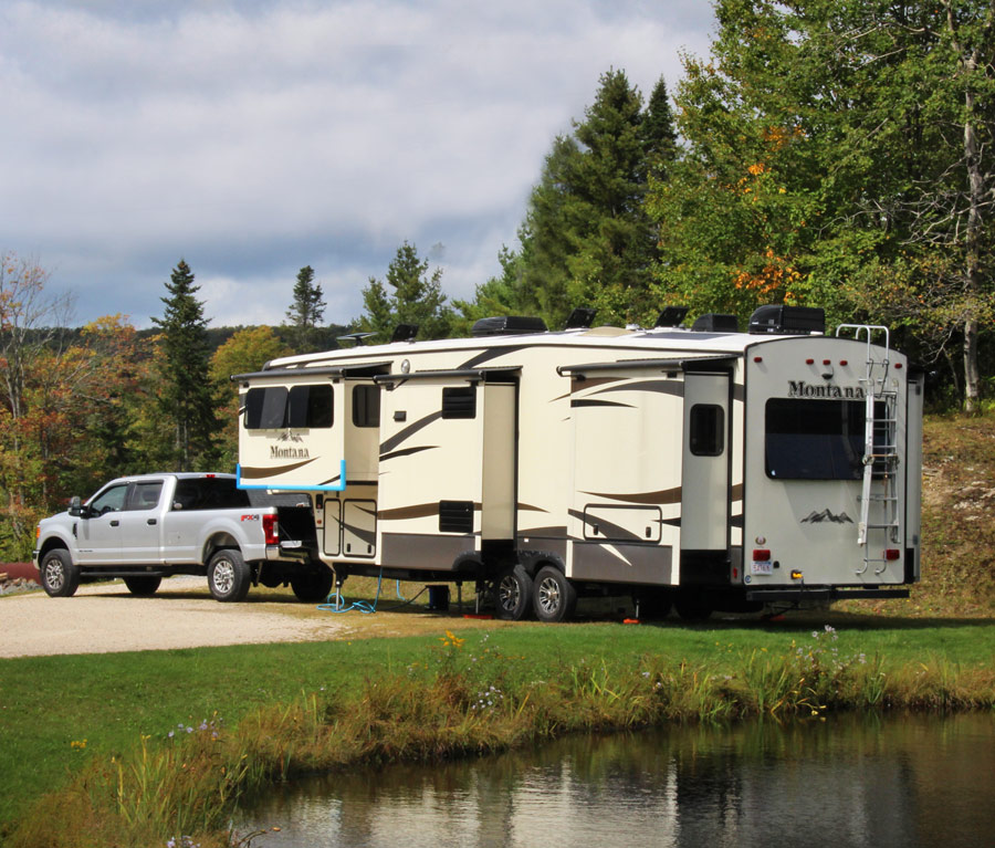 Truck and trailer parked next to body of water