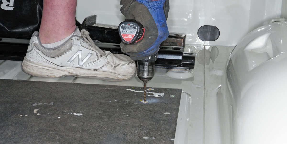 Once the technician is sure that the template is positioned correctly, pilot holes are drilled through the truck bed