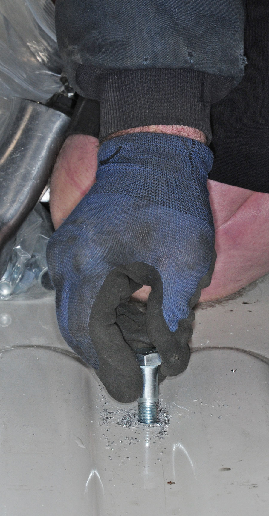 Bolts are test fitted through the truck bed and frame brackets to make sure they can be threaded into the flange nuts