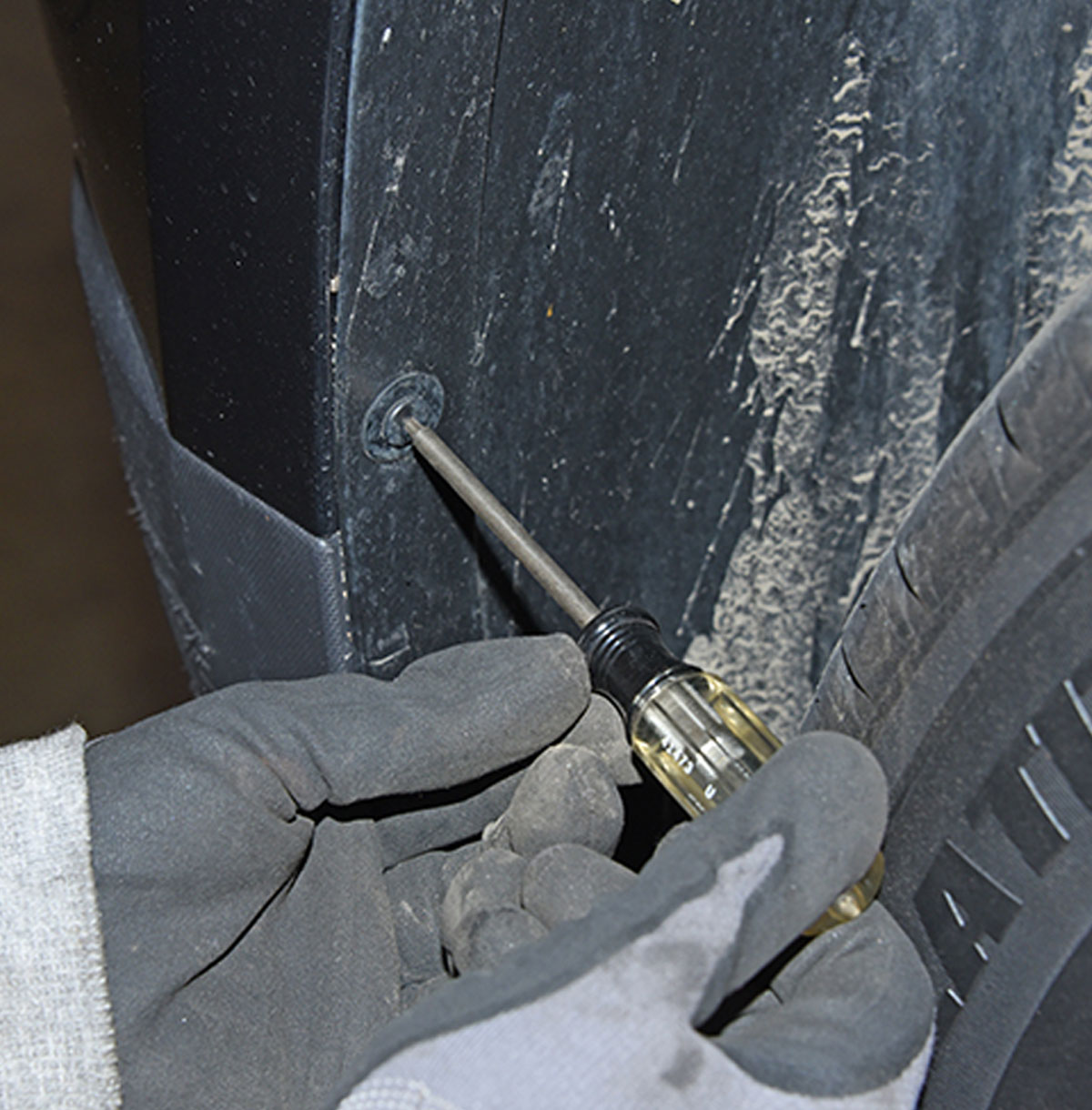 mechanic removes Torx head fastener from inner fender panel