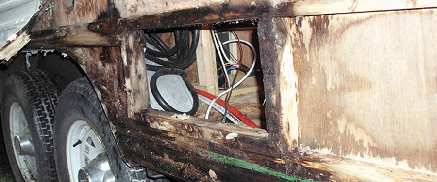 Water pouring out the open door and from under the trailer