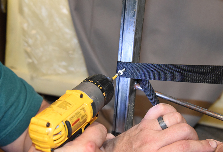 drilling a screw into the strap
