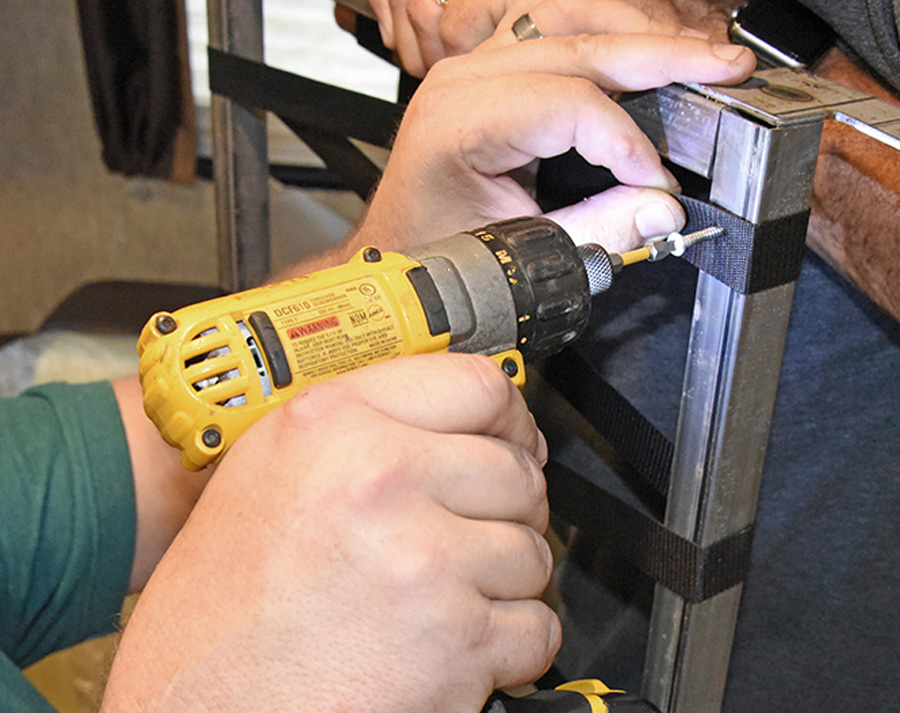 continue to pull the strap tight and insert more screws