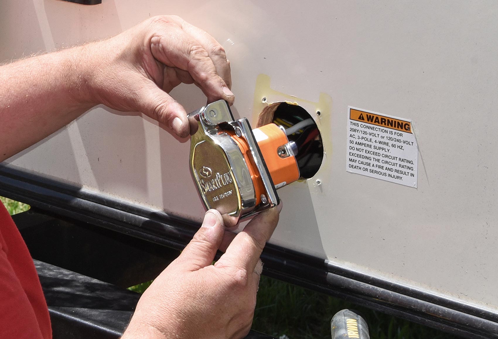 RV mechanic installs a SmartPlug piece to the outside of an RV
