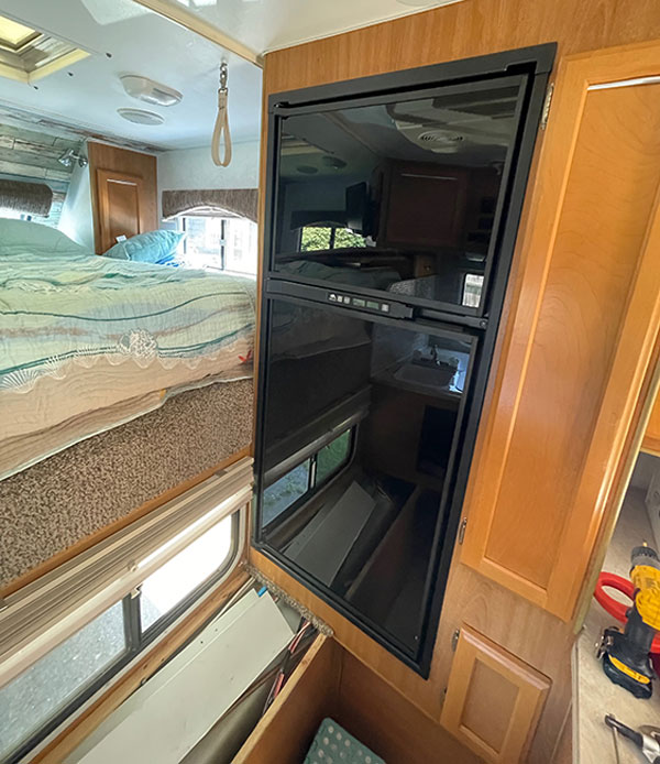We could have retained the original wood panels from the old fridge but found that the black plexiglass panels on the Norcold matched the other appliances and looked sharper