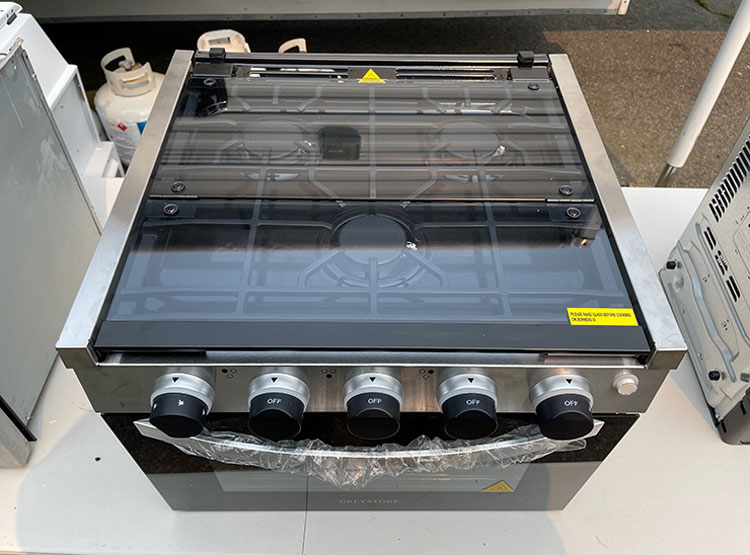 The new Greystone range top is made of attractive tinted safety glass with rubber bumpers, and folds into a backsplash