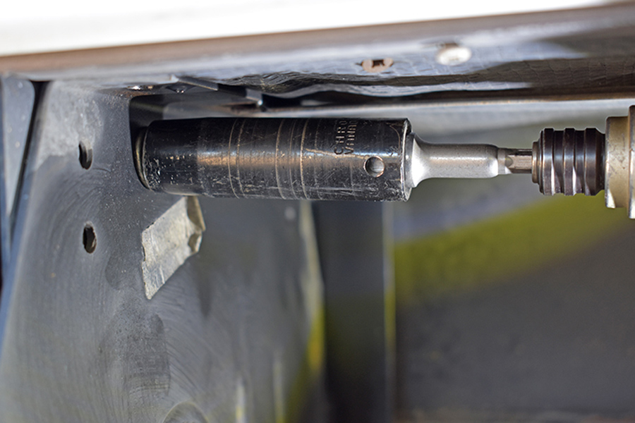 Bolts securing the original steps are removed from the factory side frame panels