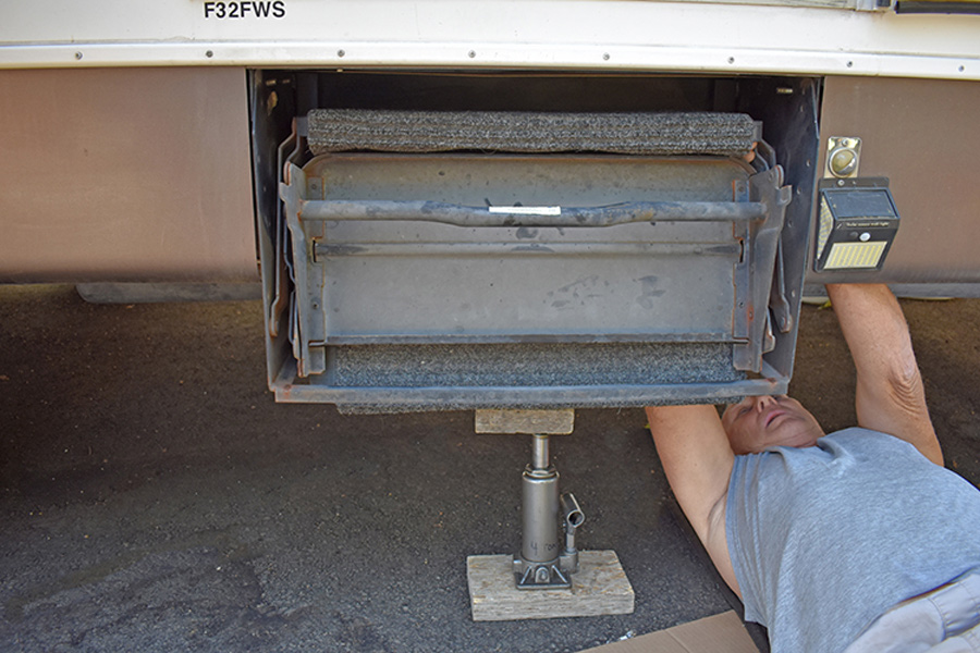hydraulic bottle jack and wood block are placed under the bottom step of the original system to ensure safety when removing the bolts