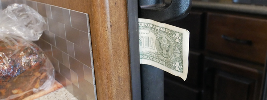 dollar bill slid between a fridge door