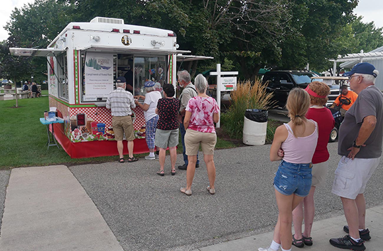 attendees stand in line at a food trailer