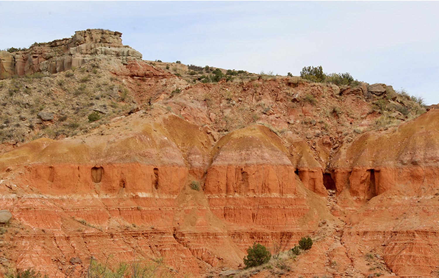 view of rust and ocher-colored layer within high cliffs