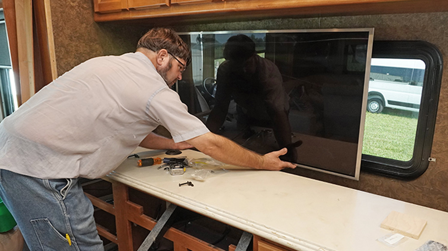 the TV Is removed from the original mounting position on the shared wall with the bathroom and attached to the lift mechanism built into the dinette/credenza