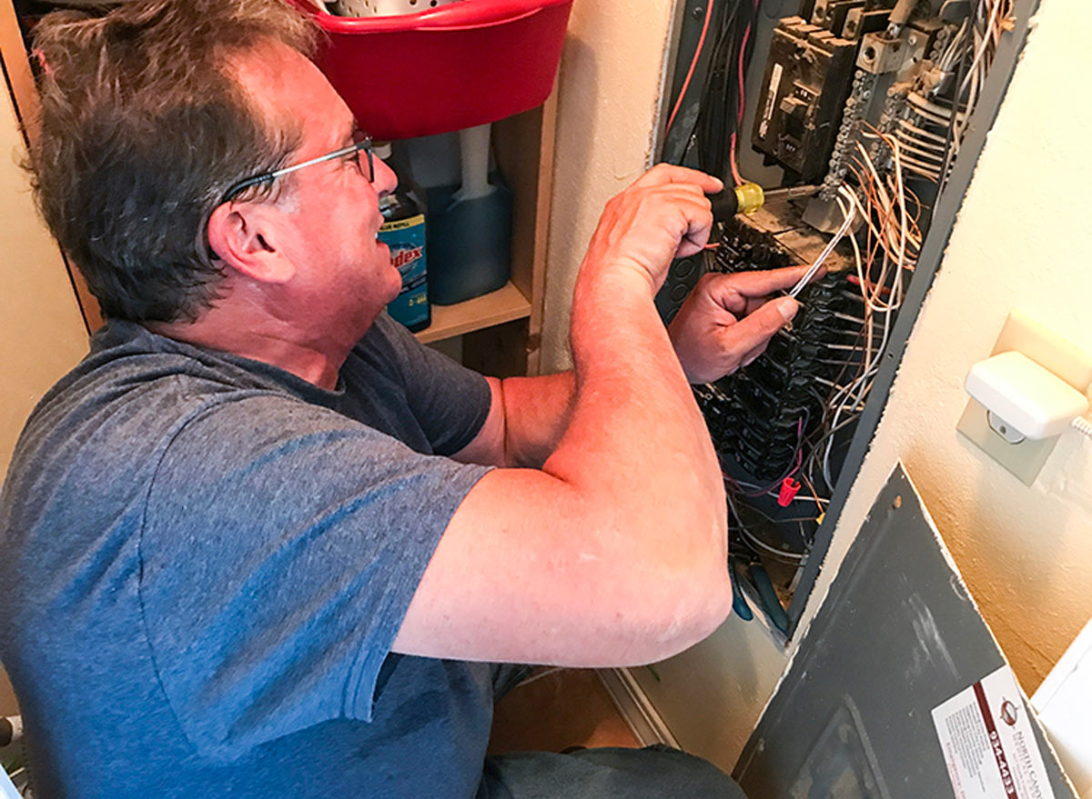 mechanic secures the new wiring for the 50-amp service to the house main circuit breaker panel