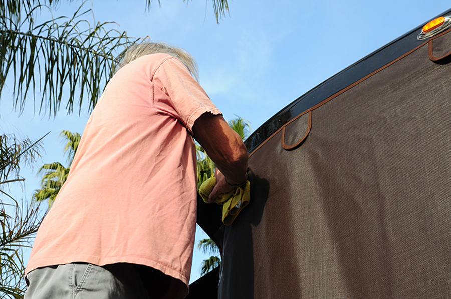 windshield being prepped by man in peach shirt