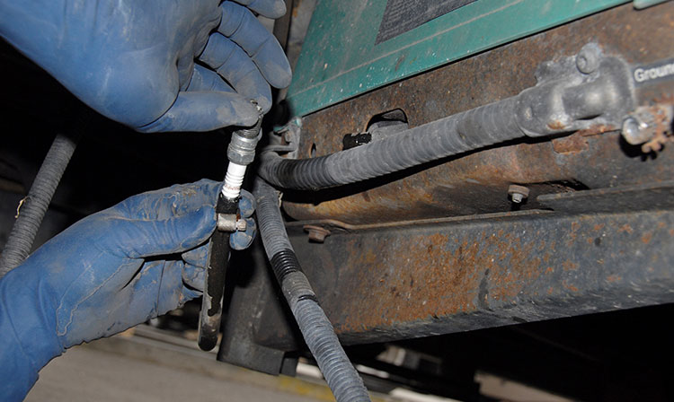 The technician used an old spark plug in the line after it was cut to prevent fuel from dripping
