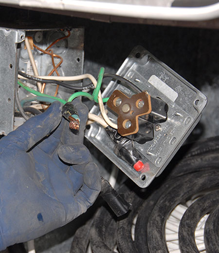 Removing four screws releases the cover, revealing the wiring inside