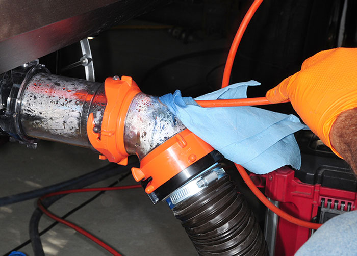 A towel is used to “plug” the hole in the fitting while the hose is moved in and out