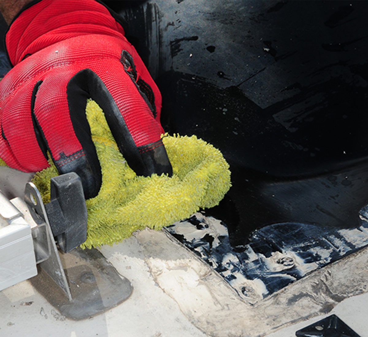 with the sealant removed, the mechanic uses a towel to clear and residue of the old sealant
