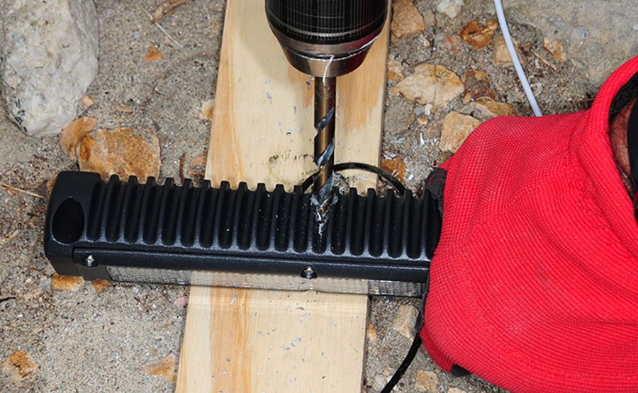 new light fixture being prepared by drilling a hole in the side of the base