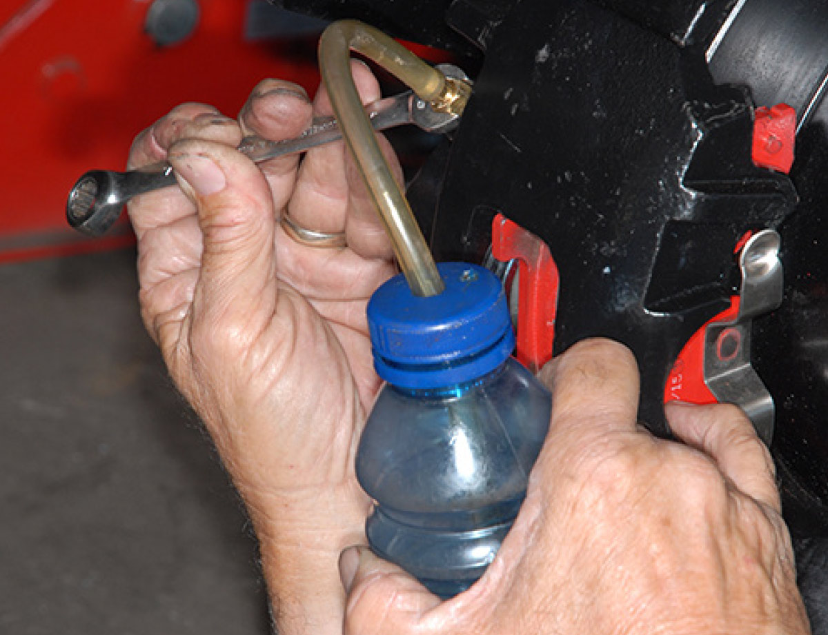 To bleed the brakes, use a clear water bottle with a small amount of brake fluid