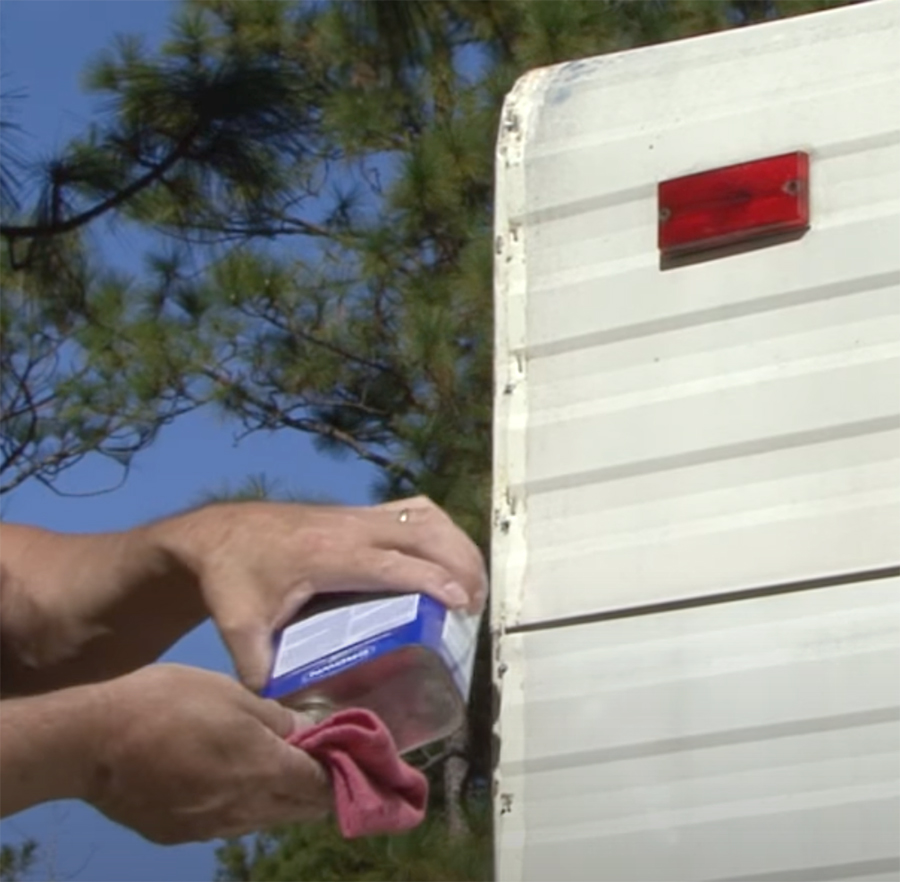 hand cleaning the area on the RV where the molding will be reattached