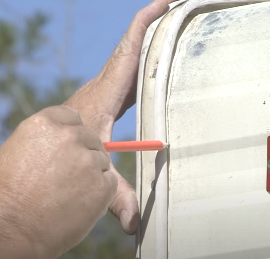 hand with pencil making sure the corner seal is applied accurately