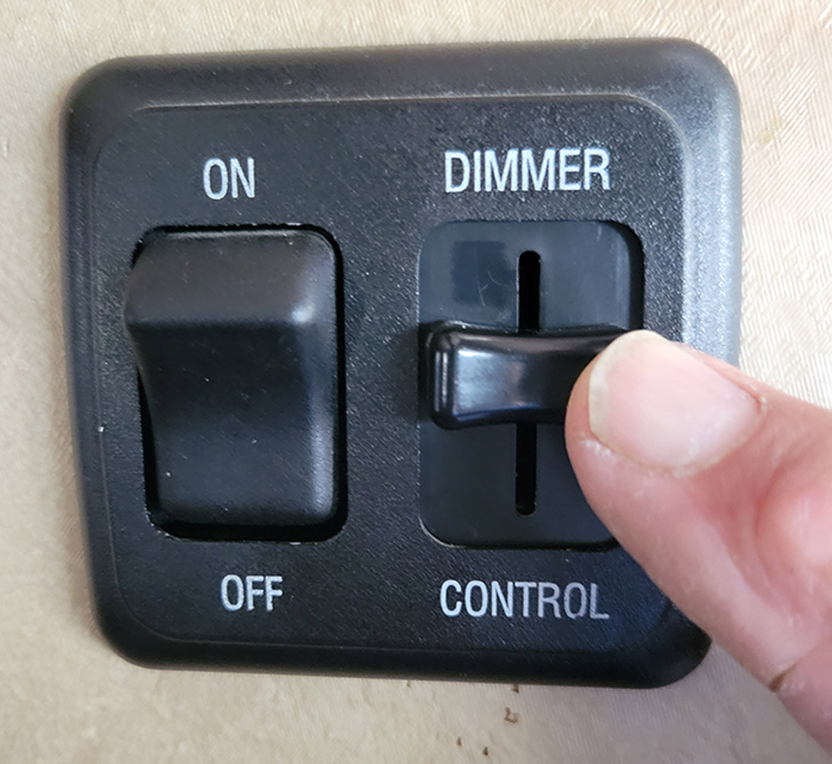 close view of a finger on a dimmer switch