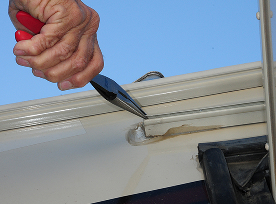 opening up the end of the awning rail slightly with a long-nose pliers