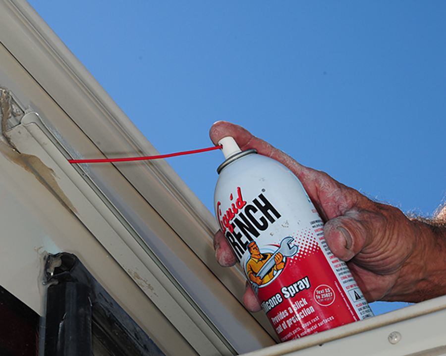 Spraying the awning rail with silicone