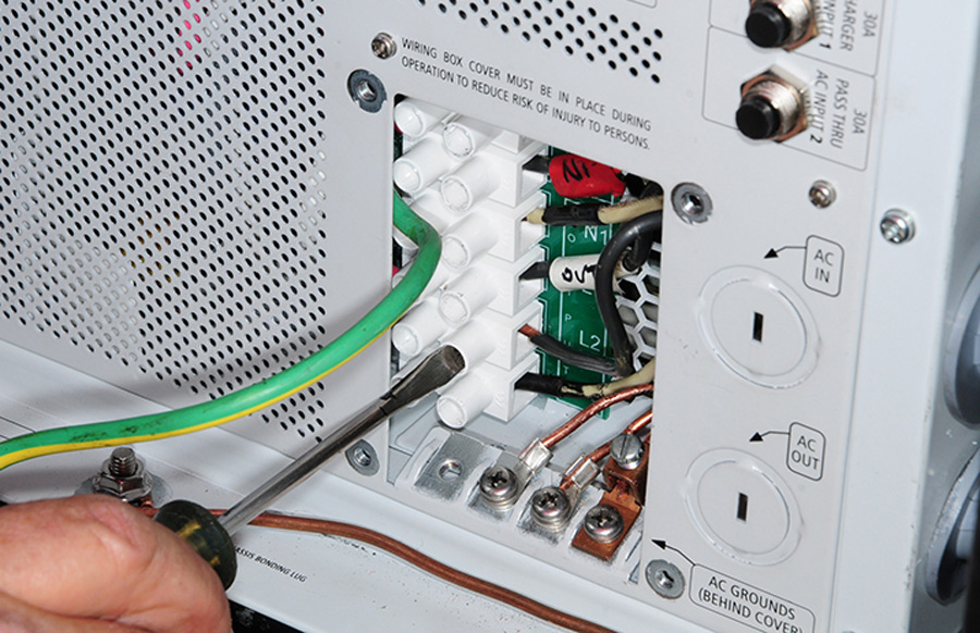 AC input and output terminals are clearly marked inside the access panel