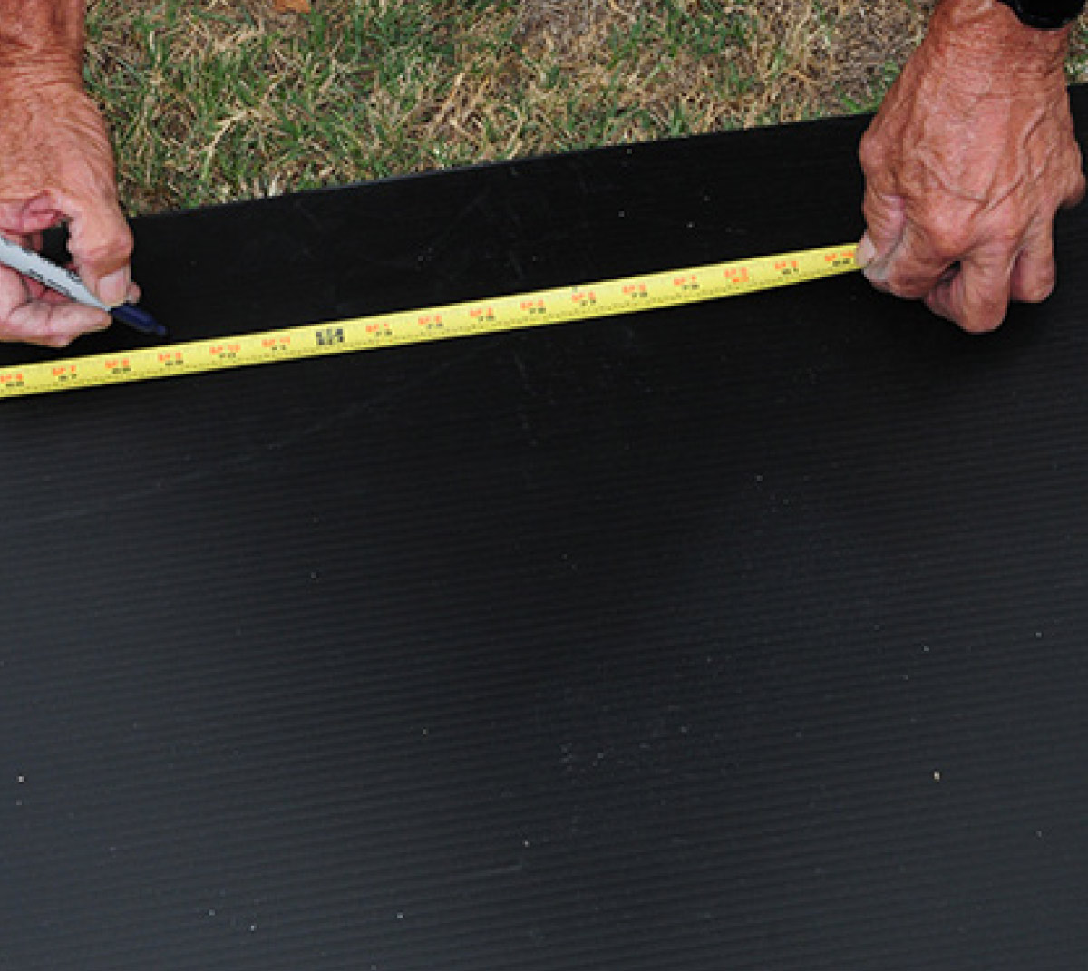 The 4 x 8-foot sheet of Coroplast was placed on the grass for drawing the cut lines