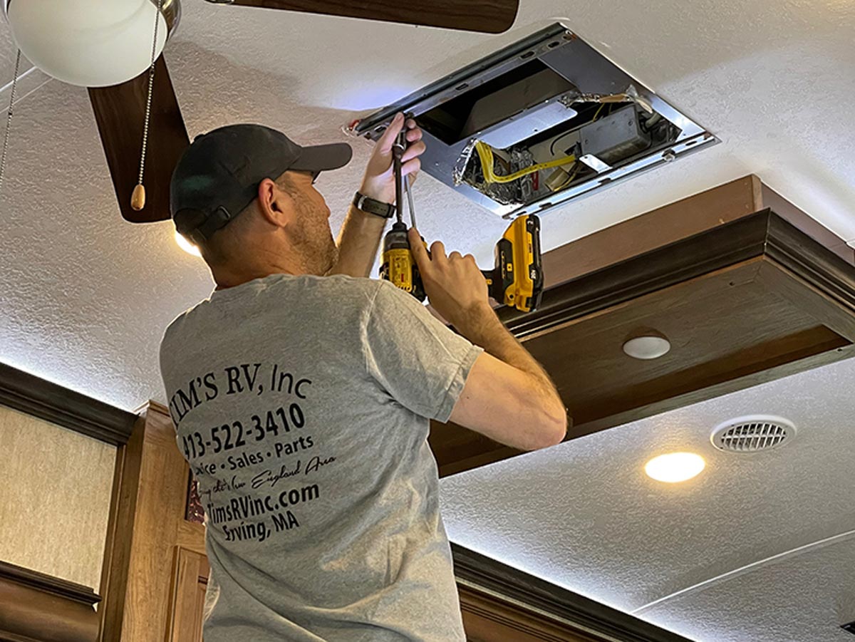 man installing an air-conditioning system in his RV