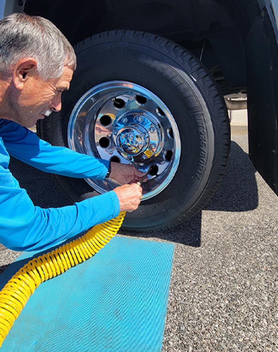man putting air in his RV tires