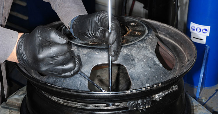 After threading the extension through the hole in wheel, the retaining nut is tightened, which compresses the gasket and makes a leak-proof seal