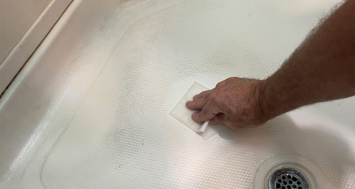 Man cleaning shower floor with Mr. Clean Magic Eraser