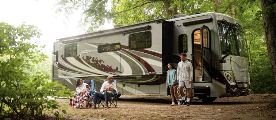 family outside of an RV in the woods