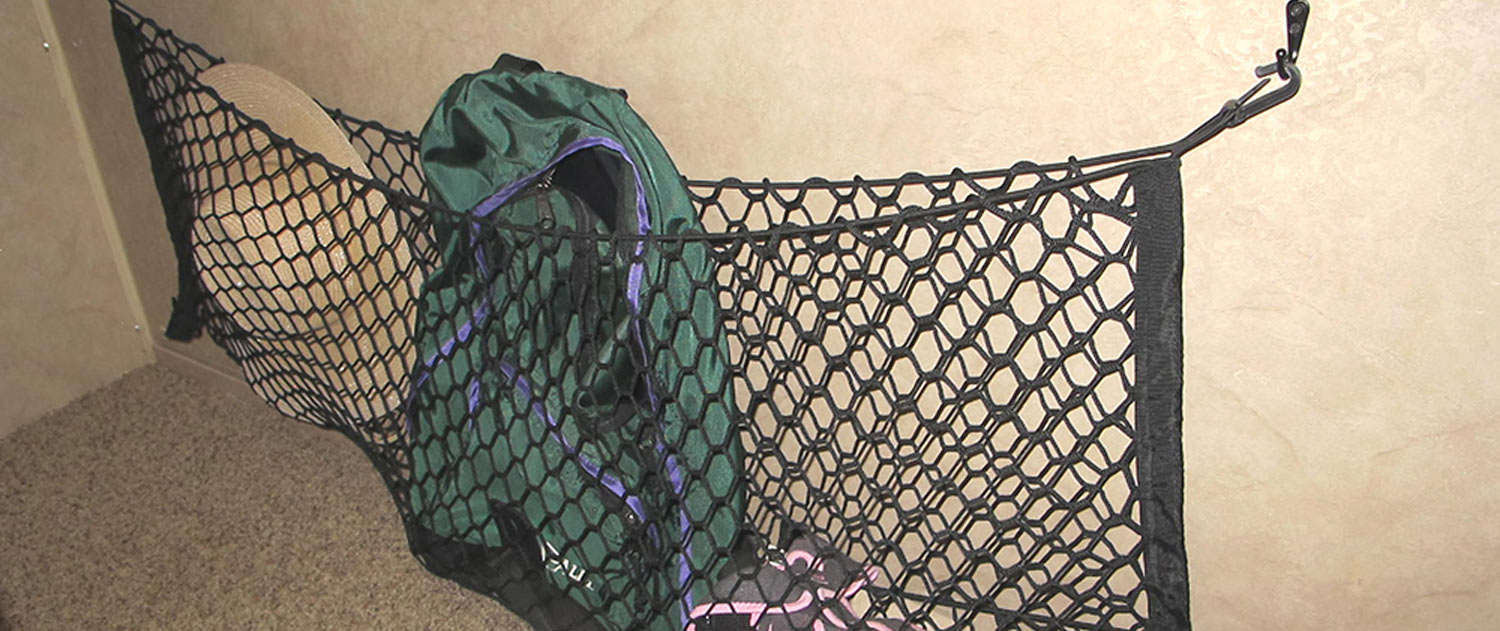 a cargo net hangs from hooks on a wall holding items secure