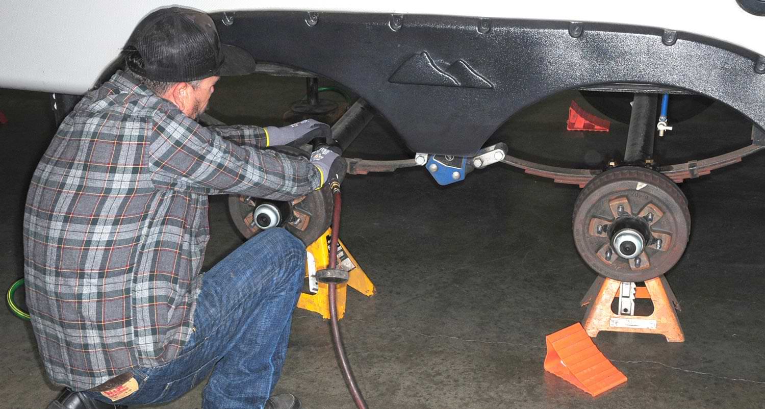 a mechanic works on the shocks of an RV