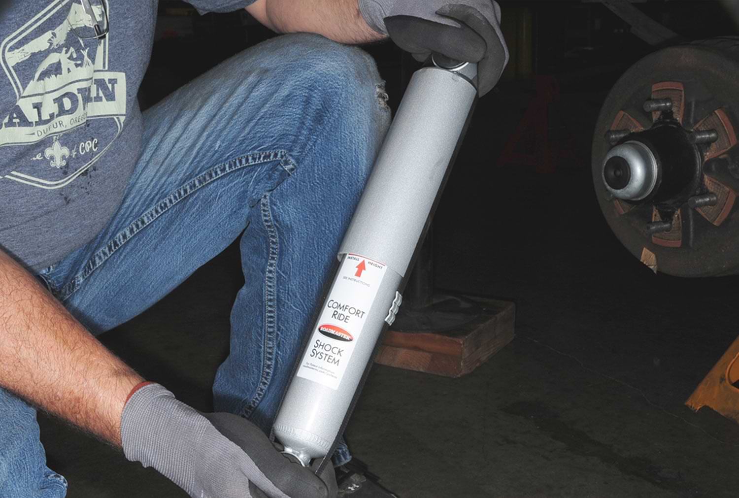 a mechanic holds a Nitrogen-charged gas shock from Roadmaster