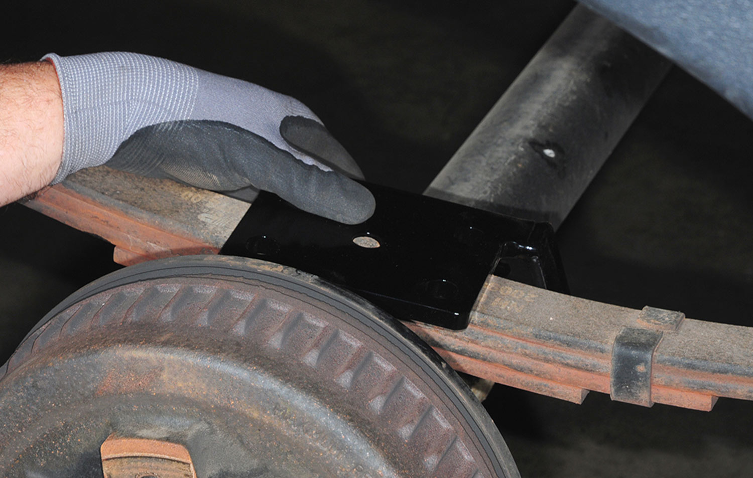 a new tie plate from the kit is placed over the locating pin on the spring pack and axle