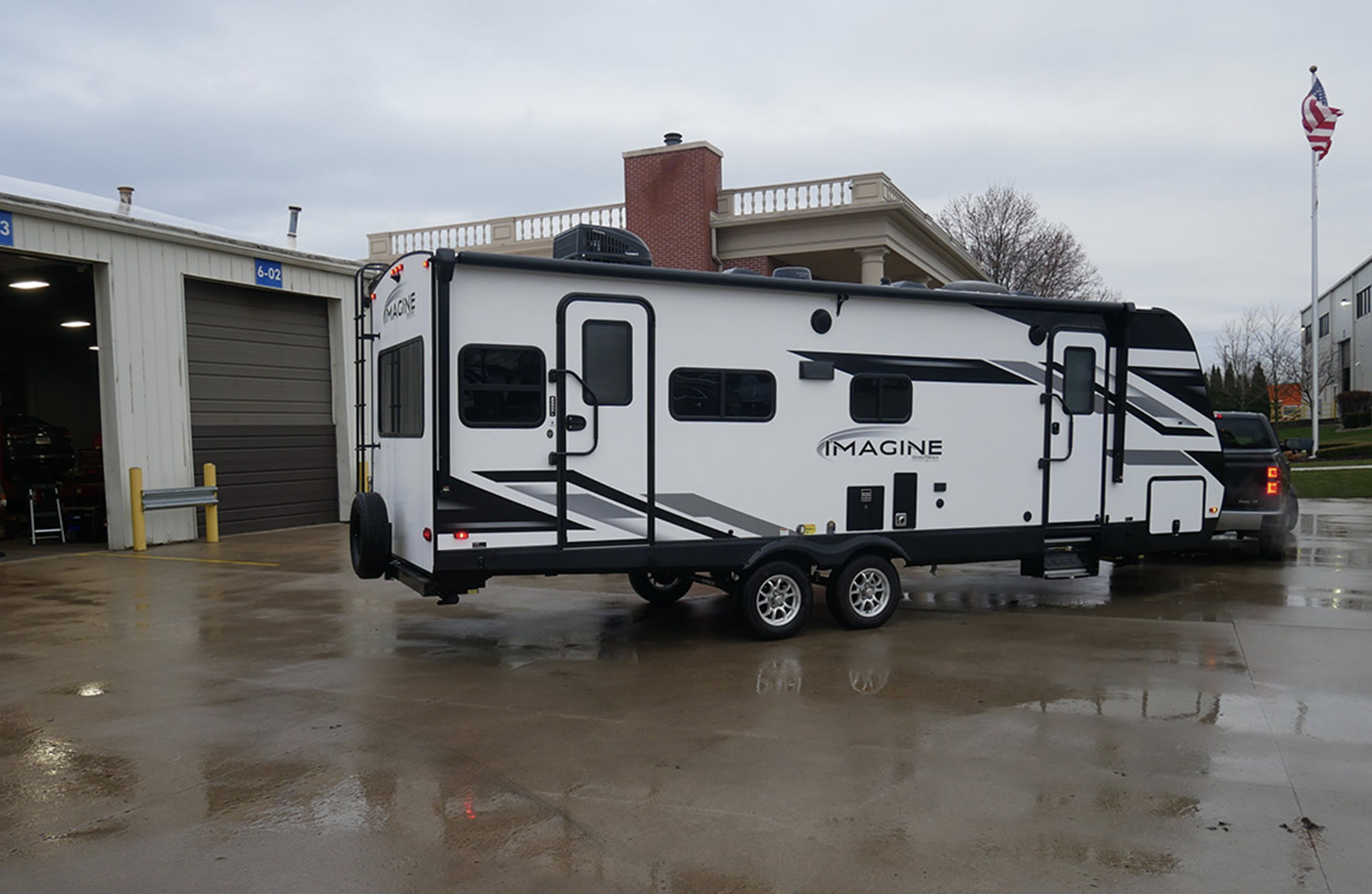 a Grand Design Imagine 2500RL is pulled by a truck in a lot