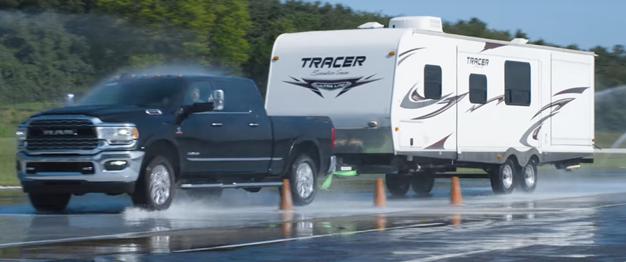 truck towing a trailer driving on wet roads